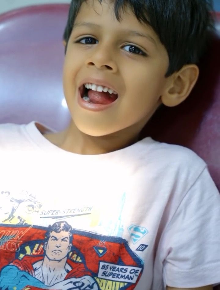 A young patient smiling happily in the dental chair