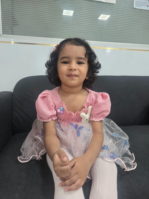 A young patient smiling in the waiting area of The Tooth Corner