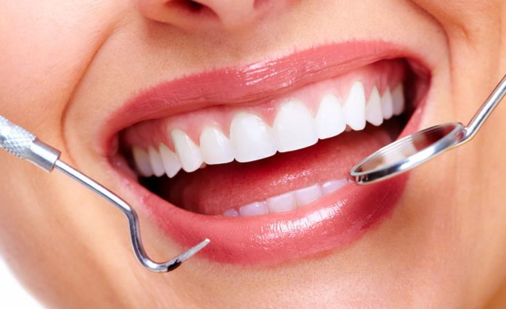 A patient admiring their brighter, refreshed smile in a mirror after cosmetic dentistry at The Tooth Corner, Bellandur